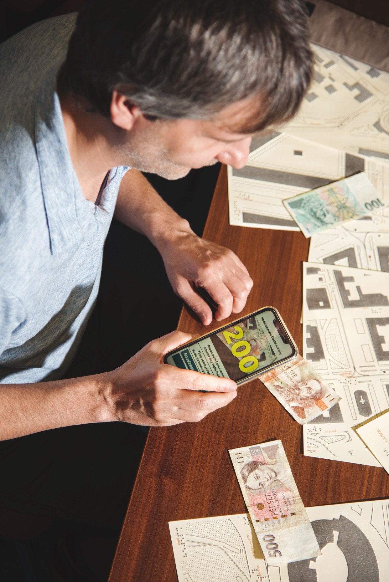 A blind person using Cash Reader to identify banknotes